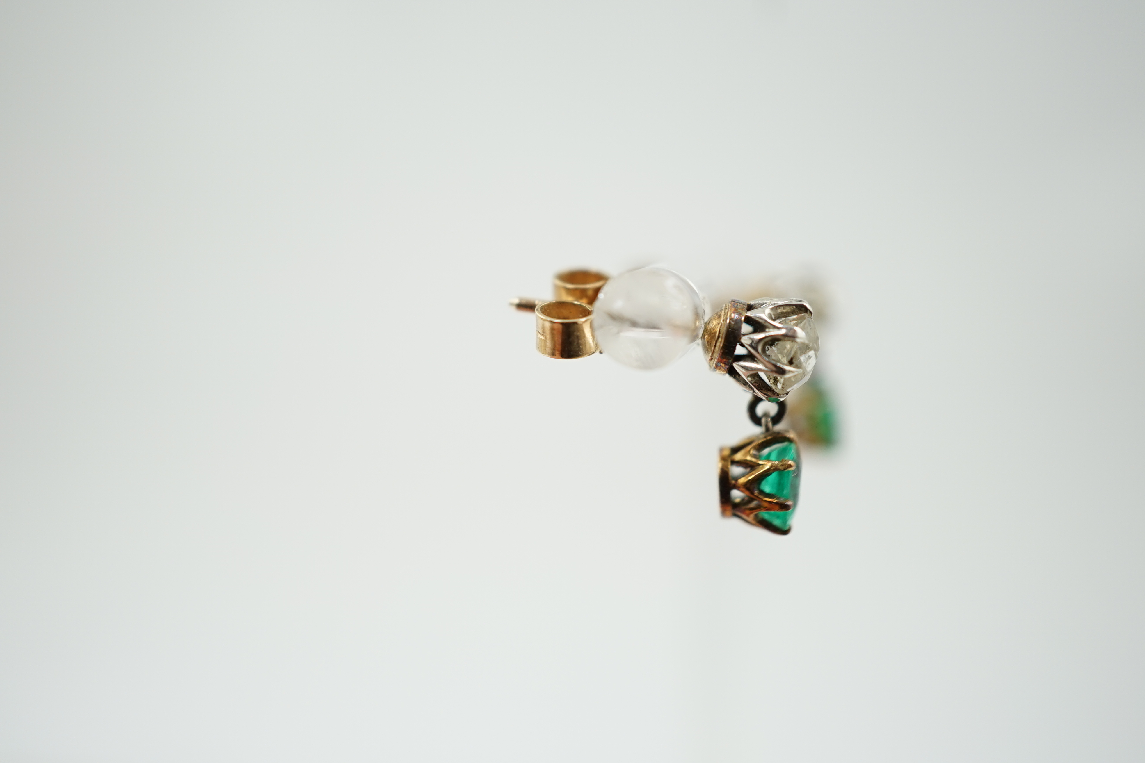 A pair of late 19th/early 20th century gold and platinum, emerald and diamond set two stone drop earrings